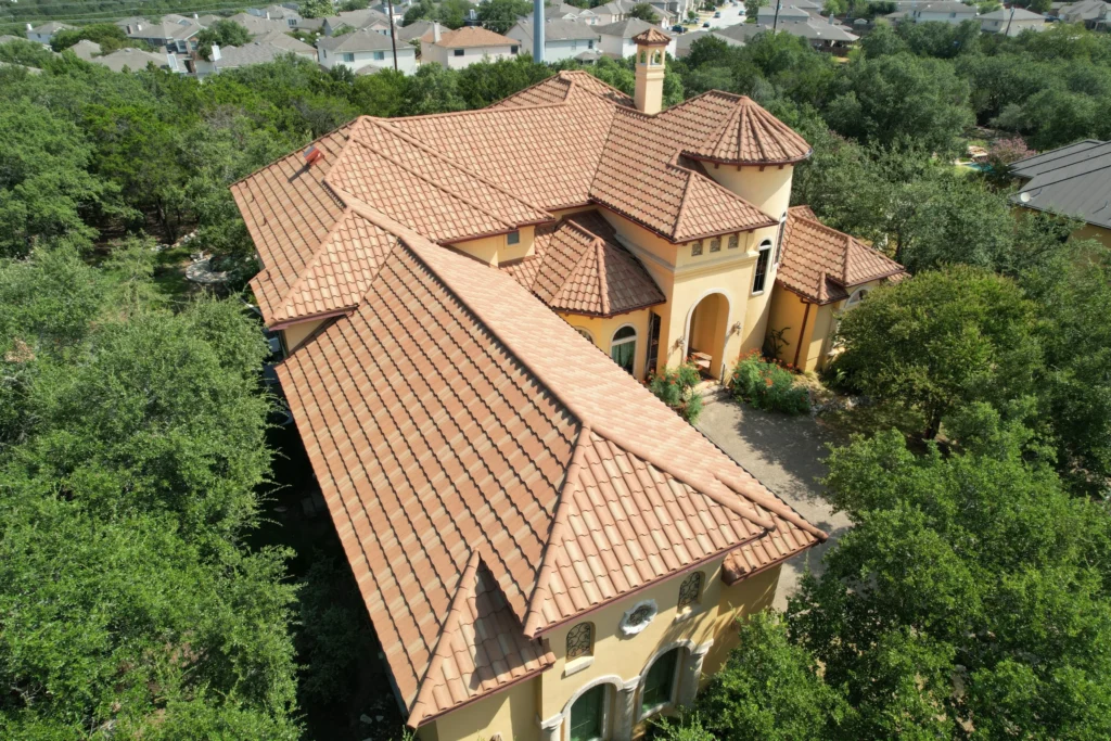 Image shows roof of Spanish colonial style home with terra cotta color roof using Decra steel roofing tiles which mimic the appearance of traditional clay tiles.