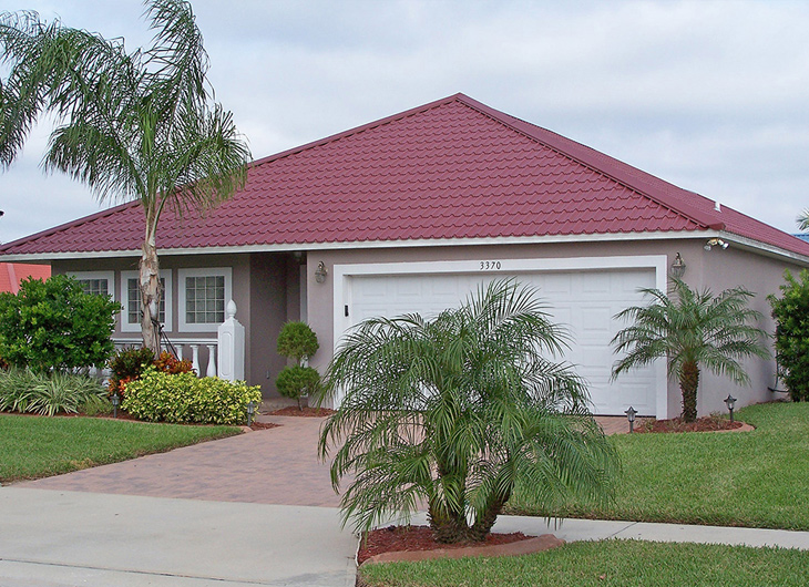 Image shows a Florida home with a steel roof by Permatile which has the appearance of a red tile roof.